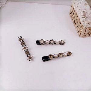 Detail view of retro Baroque hair clips with white pearls and sparkling crystals