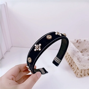Detail of handmade vintage velvet headband with pearls, crystals, and hand-made label