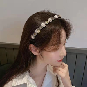 Detailed side view of luxury headband with crystal flowers and gold vintage coin charms