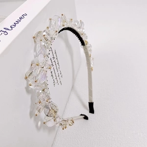 Detailed close-up of large iridescent crystals and gold beads on an elegant headband