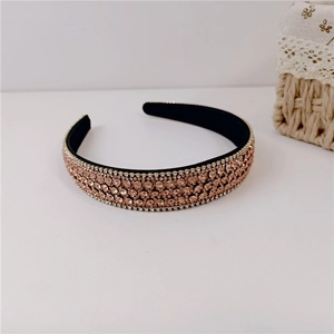 Macro shot of rose gold rhinestones on black headband with lace basket decor