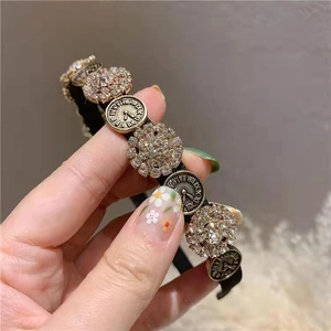 Close-up of vintage headband with crystal clusters and Roman numeral clock charms