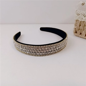 Detail shot of wide black velvet headband with multi-row rhinestones and gold edges