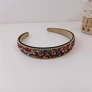 Detailed close-up showing multicolored rhinestones on a black fabric headband