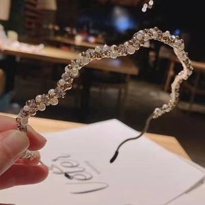 Elegant wavy pearl headband with sparkling crystals and gold base for party hair styling