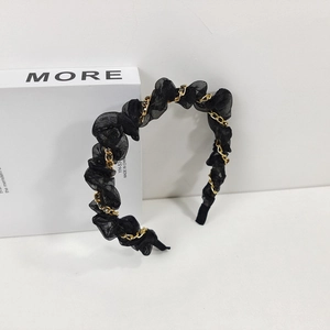 Eleganter schwarzer Organza-Haarreif mit Goldkette und Strass auf weißem Hintergrund