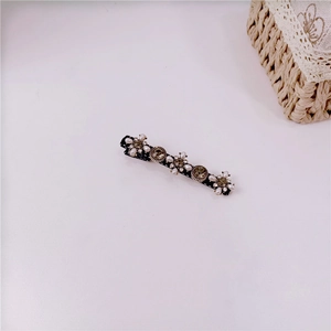 Close-up of vintage baroque hair clip with white pearls and champagne rhinestones