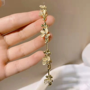 Elegante cerchietto dorato con petali di fiori in opale crema e strass in cristallo lucido