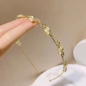 Elegante cerchietto dorato con petali di opale e strass scintillanti sui fiori
