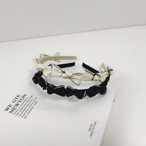 Détail de serre-têtes à nœuds noir et beige avec un style français chic et élégant