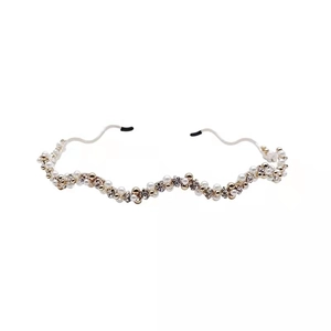 Detailed view of wavy gold headband featuring alternating pearls and sparkling rhinestones