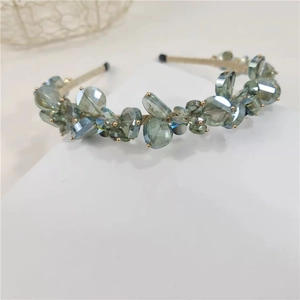 Detailed macro view of large teal faceted crystals on a refined woven headband hairpiece