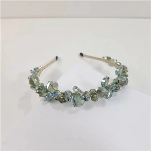Detail of elegant gold headband featuring clustered green and blue faceted crystal beads