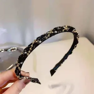 Detail of black tweed headband featuring delicate gold beads and white pearl chains