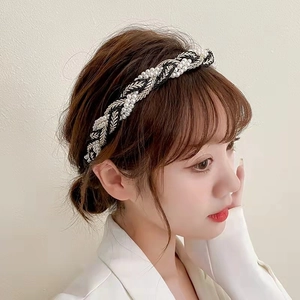 Detailed view of woven pearl headband with elegant silver and black braided textures