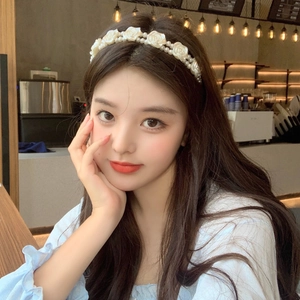Detailed view of elegant white rose flowers and double-layer pearl beads on a retro headband