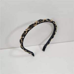 Detail of woven fabric headband featuring gold metal beads and white pearls in French style