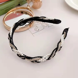 Close-up of retro woven headband with white faux pearls and golden silk thread details