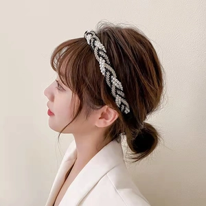 Side view of woven pearl headband featuring gold thread and delicate leaf textures
