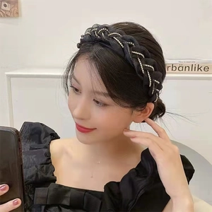 Dettaglio del cerchietto in pizzo intrecciato nero con decorazioni in strass brillanti