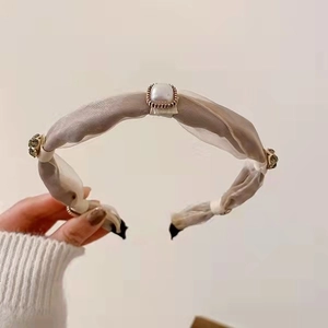 Close-up of elegant mesh headband with square pearl and rhinestone embellishments