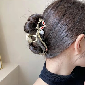 Détail de la pince à cheveux renard doré avec émail rouge et perle sur un mannequin