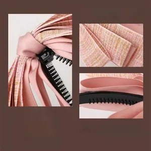 Close-up of pink tweed fabric texture and black plastic teeth on the banana hair clip