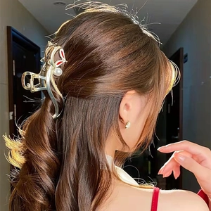 Détail de grande pince à cheveux renard doré avec perle sur une coiffure élégante