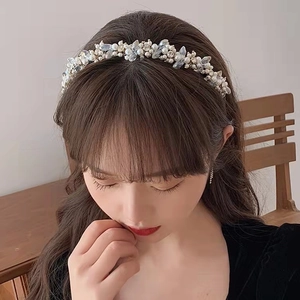 Détail d'un serre-tête élégant avec perles blanches et cristaux sur cheveux foncés