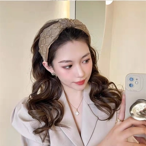 Detailed view of light brown quilted headband with delicate crystal embellishments