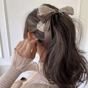 Detail of elegant large double-layered bow hair clip on model with wavy hair