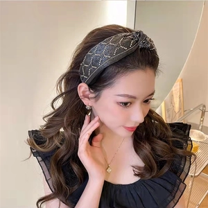 Side view of a twisted knot headband with sparkling rhinestones in a lattice pattern