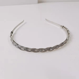Detail of silver twisted metal headband showing the intricate braided texture and design