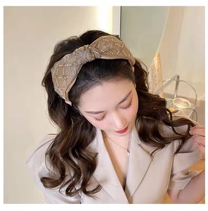 Detailed view of champagne gold knot headband with luxury rhinestone lattice patterns