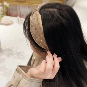 Close-up of champagne gold mesh headband with intricate pearl and rhinestone patterns