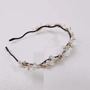 Détail d'un serre-tête fait main avec perles blanches et cristaux sur fil métallique noir