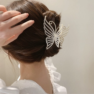Elegant gold butterfly hair claw clip with pearls shown in a hair styling back view