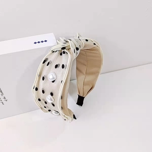 Beige polka dot knotted headband with white square pearls and elegant silk texture