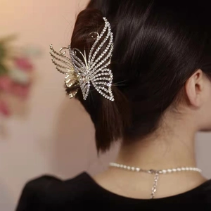 Detailed view of silver butterfly claw clip with rhinestones worn on elegant hairstyle