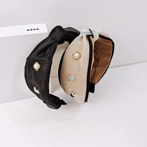 Detailaufnahme von breiten Haarreifen mit Perlen und Herz-Strass-Verzierungen