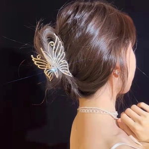 Detail of elegant pearl butterfly hair claw clip with rhinestones worn on hair