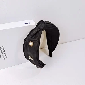 Eleganter schwarzer Satin-Haarreif mit Perlen und Strassherz auf einer weißen Dekobox