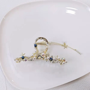 Dettaglio della molletta per capelli a tema marino con stelle marine e nappe di perle