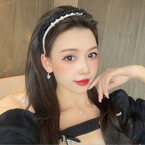 Detail view of vintage French pearl headband with black velvet pleated texture on a model