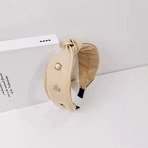 Eleganter breiter Haarreif in Beige mit Perlen und funkelnden Herz-Applikationen