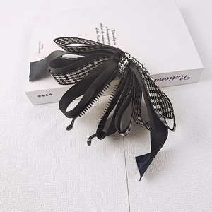 Détail de la barrette à nœud pied-de-poule avec son design de griffe intérieure robuste