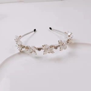 Dettaglio del cerchietto con fiori di cristallo bianco, petali perlati e strass luminosi