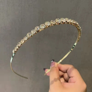 Serre-tête élégant en métal fin orné d'une rangée de strass étincelants pour femme