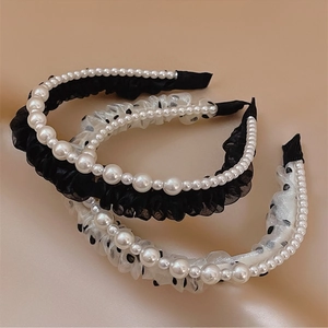 Detailed view of pearl headbands with black lace and polka dot mesh textures