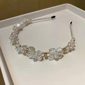 Elegante cerchietto con fiori di perle e cristalli a conchiglia su vassoio bianco